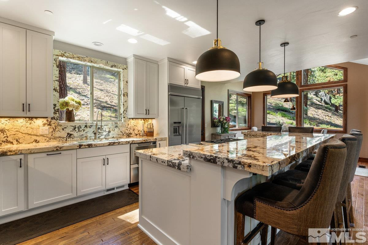 2204 Lands End Road Glenbrook, NV 89413 - Photo 6 of 40 a kitchen with granite countertop a stove a sink a dining table and chairs