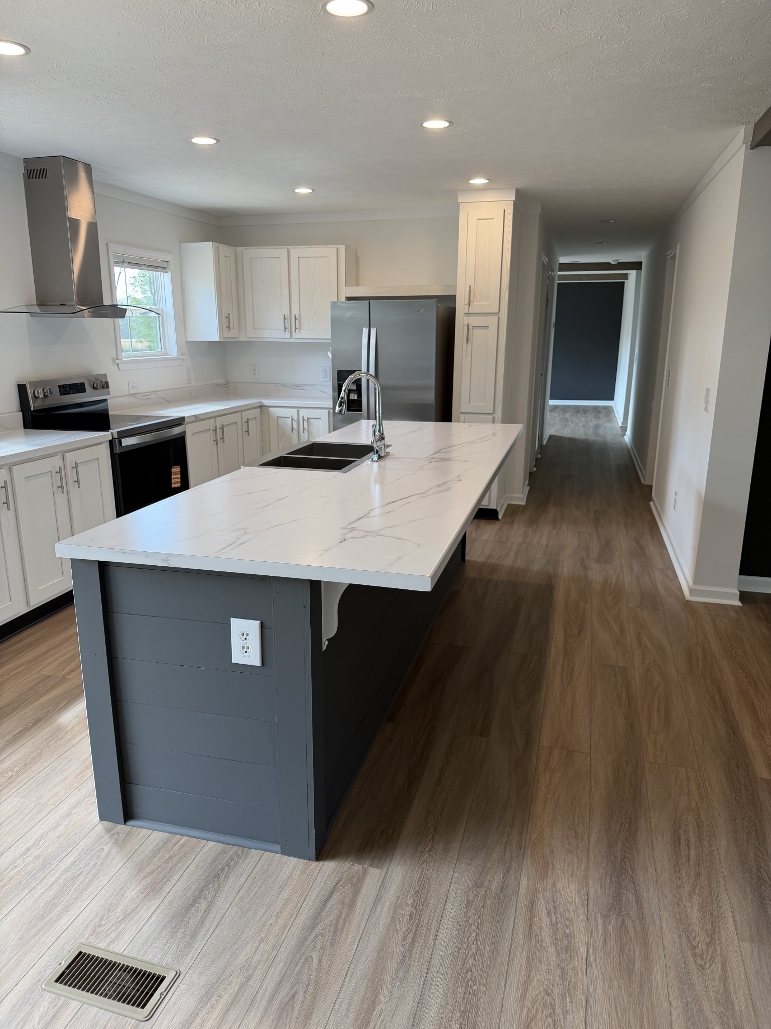 2334 Deans Shop Road Estill Springs, TN 37330 - Photo 8 of 9 a kitchen with kitchen island wooden floors wooden cabinets a sink and a counter