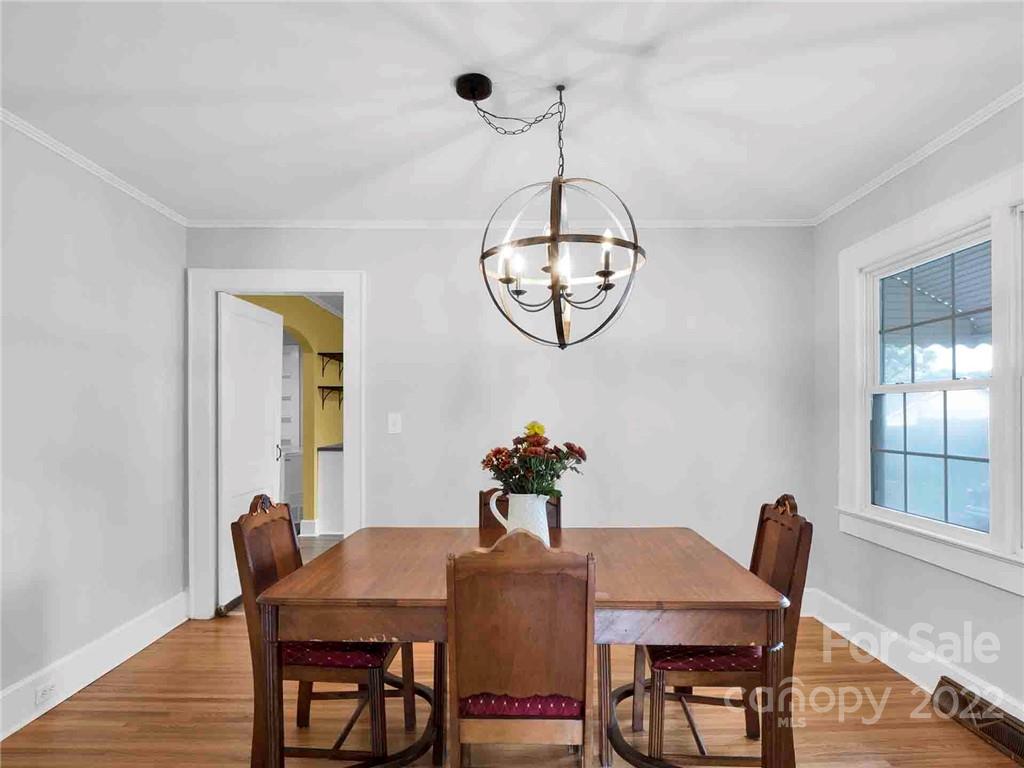 673 Union Cemetery Road Southwest, Unit 8 Concord, NC 28027 - Photo 9 of 34 a view of a dining room with furniture wooden floor and chandelier