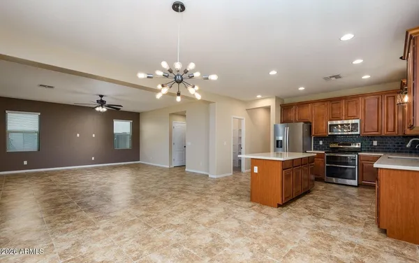 a kitchen with stainless steel appliances granite countertop a refrigerator a sink and a stove