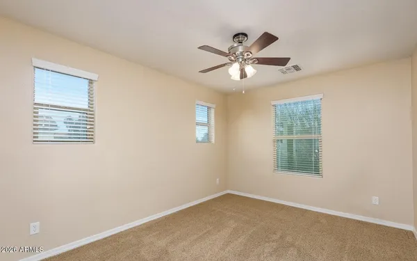 an empty room with a window and a ceiling fan