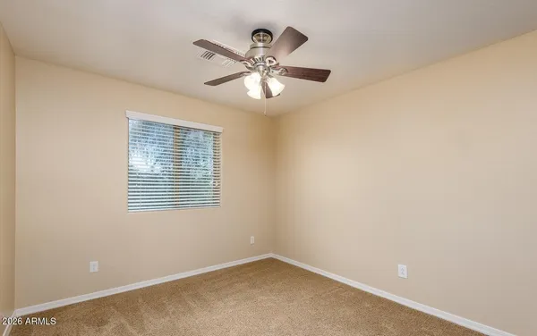 an empty room with a window and a fan