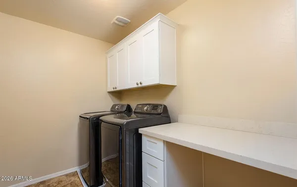 a view of a big room with windows and chandelier fan