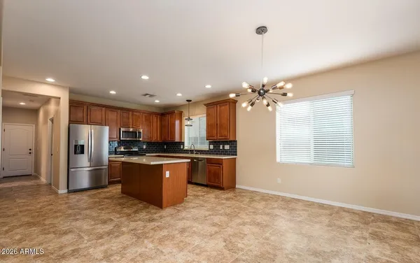 a view of a livingroom with a chandelier fan and windows