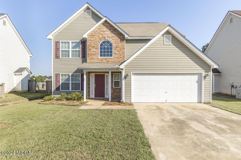 a view of yellow house with a yard and garage