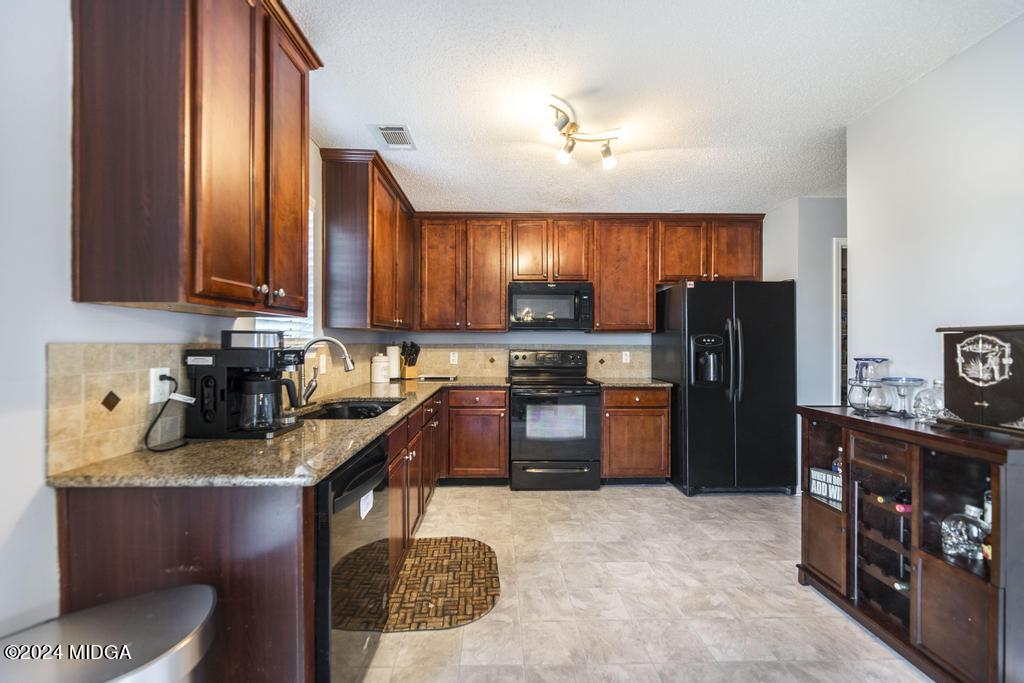 307 Timberwind Drive Byron, GA 31008 - Photo 13 of 27 a kitchen with refrigerator a stove and a wooden cabinets