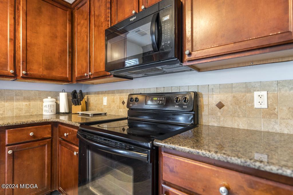 307 Timberwind Drive Byron, GA 31008 - Photo 15 of 27 a kitchen with stainless steel appliances granite countertop a stove and a microwave