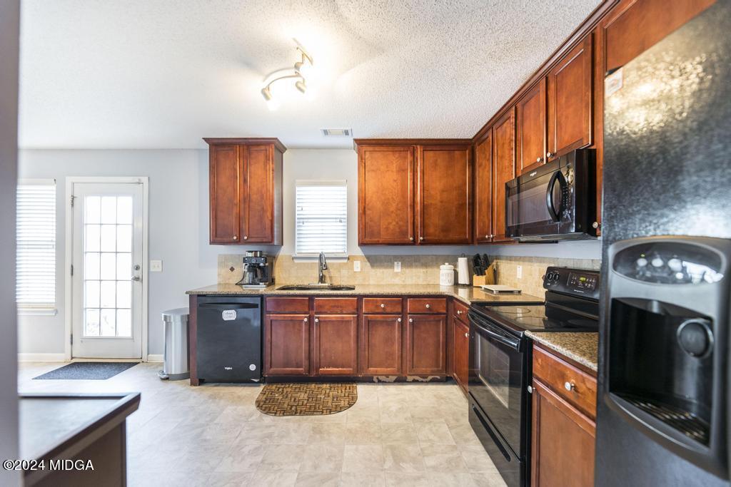 307 Timberwind Drive Byron, GA 31008 - Photo 16 of 27 a kitchen with stainless steel appliances granite countertop a stove sink and cabinets