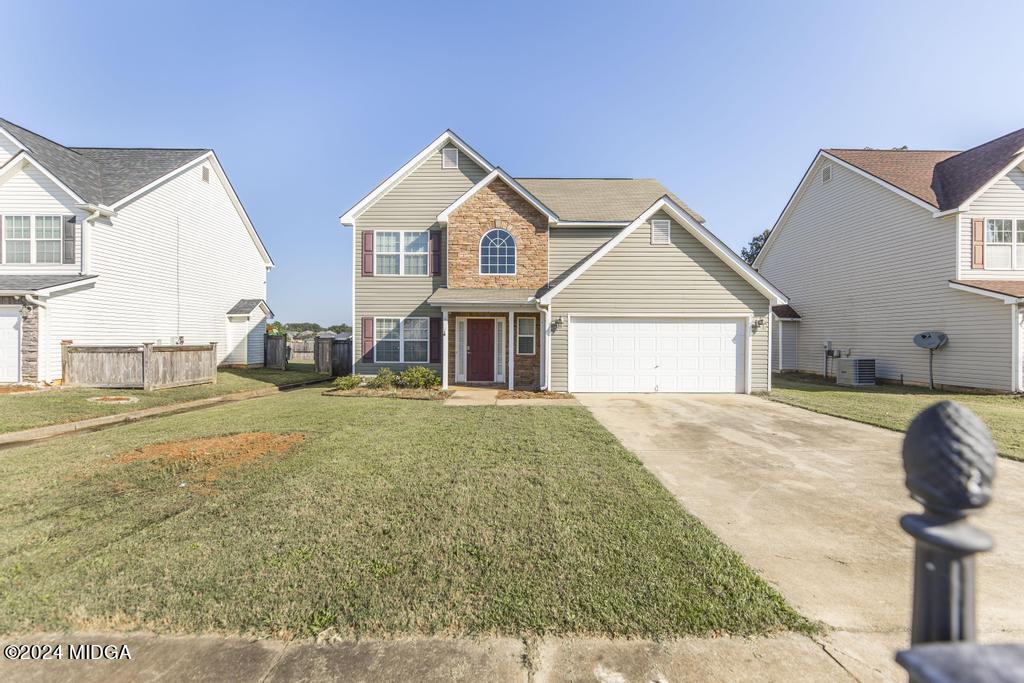307 Timberwind Drive Byron, GA 31008 - Photo 3 of 27 a front view of a house with a yard and garage
