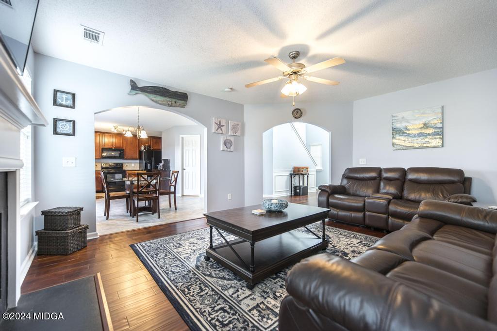 307 Timberwind Drive Byron, GA 31008 - Photo 10 of 27 a living room with furniture a rug and a chandelier