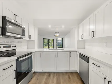a kitchen with granite countertop cabinets stainless steel appliances and wooden floor