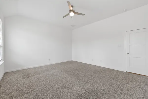 a view of an empty room with a chandelier fan
