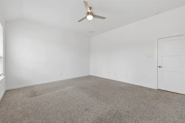 a view of an empty room with a chandelier fan