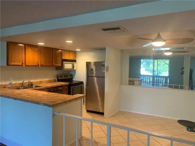 a kitchen with stainless steel appliances granite countertop a refrigerator a sink a stove a microwave and island