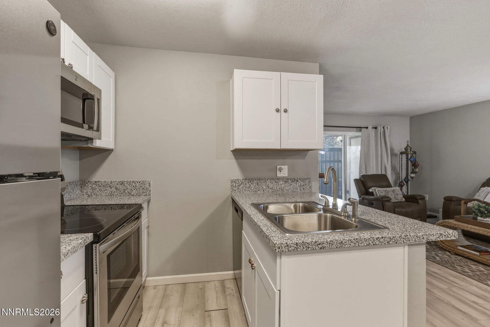 4557 Reggie Road Reno, NV 89502 - Photo 14 of 25 a kitchen with granite countertop a sink and a stove top oven