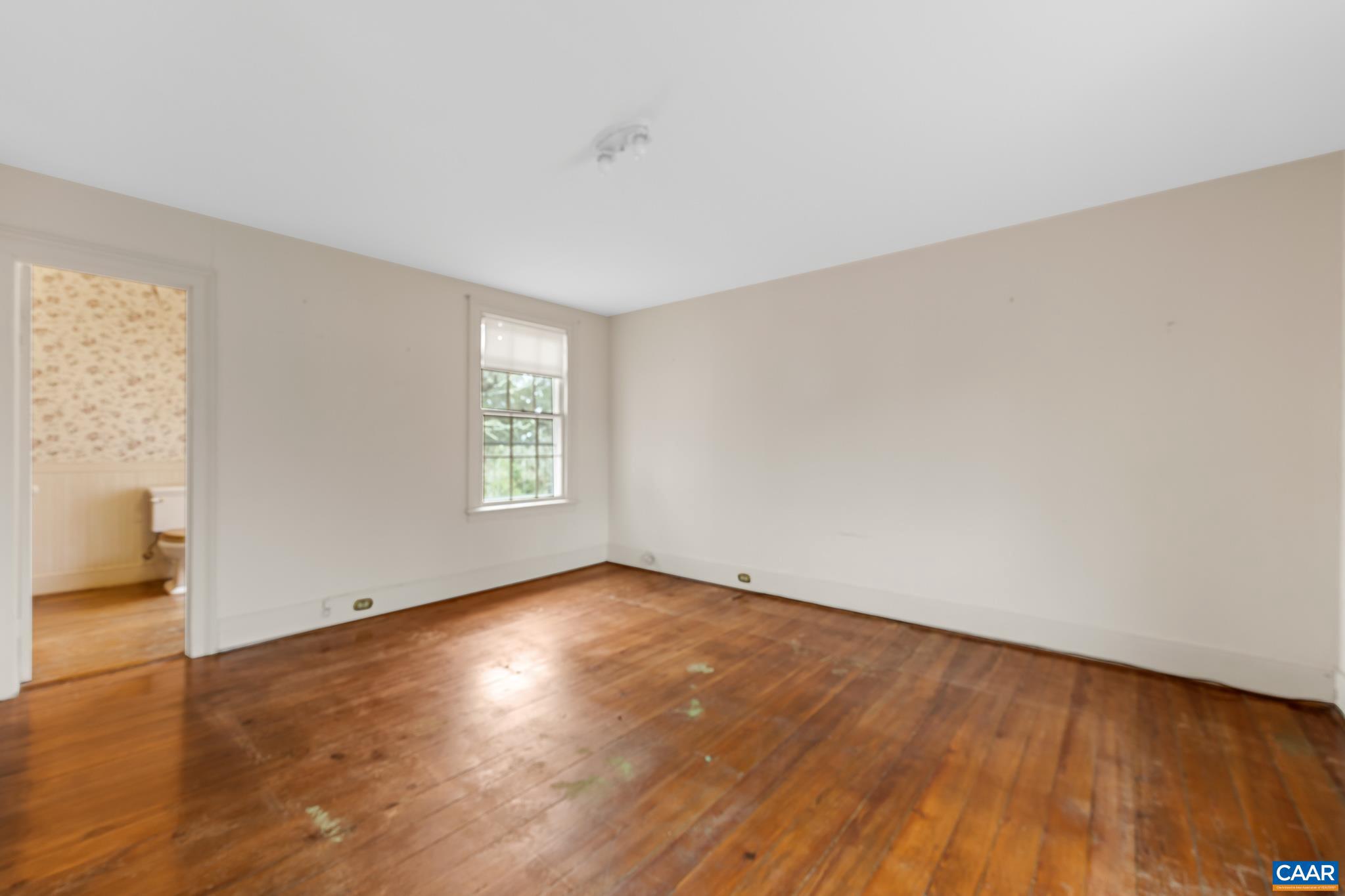 9451 Black Walnut Run Road Rhoadesville, VA 22542 - Photo 44 of 72 an empty room with wooden floor and windows