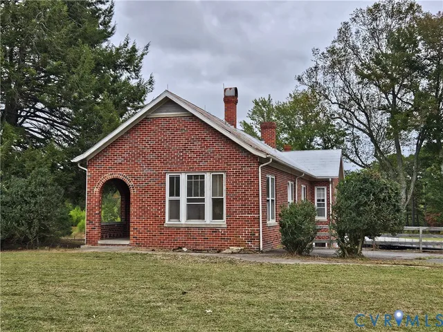 a view of a yard in front of a house with large windows