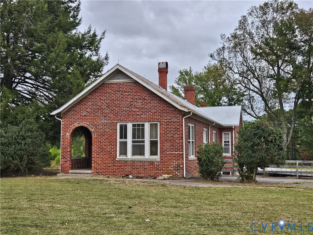a view of a yard in front of a house with large windows
