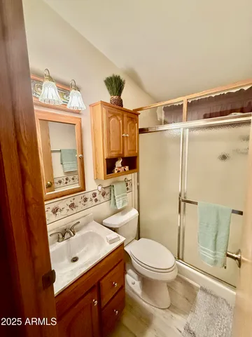 a bathroom with a sink toilet a mirror and shower
