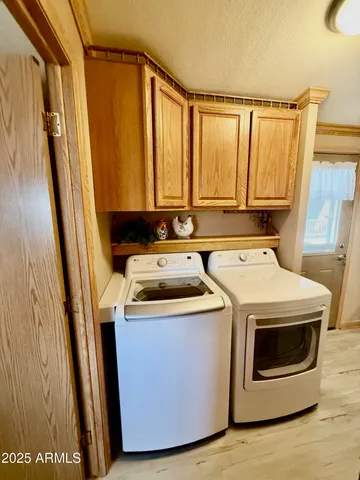 a utility room with wooden floor washer and dryer