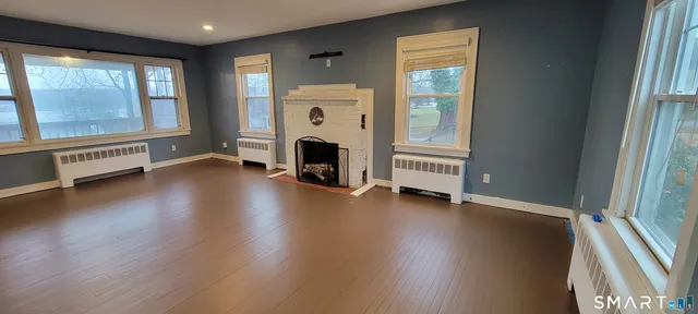 an empty room with windows wooden floor and windows