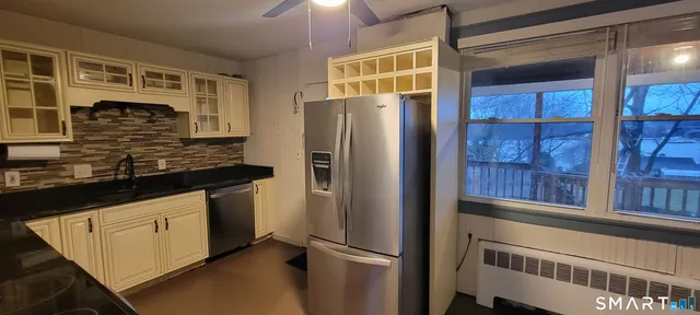 a kitchen with stainless steel appliances granite countertop a refrigerator and a sink