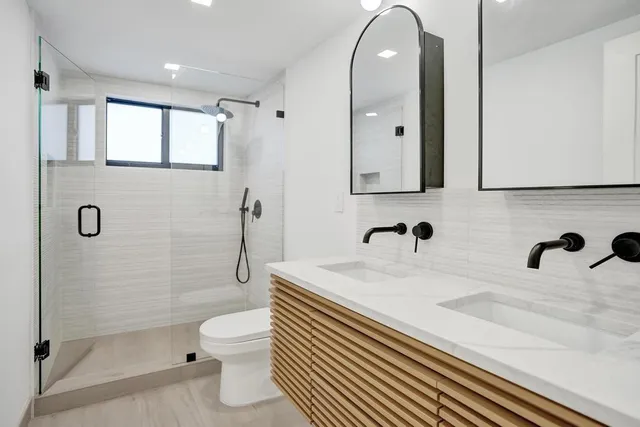 a bathroom with a sink a toilet and a large mirror