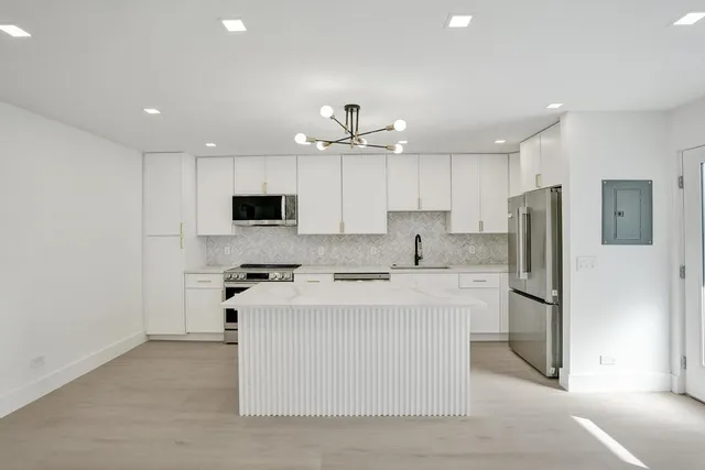 a kitchen with stainless steel appliances granite countertop a sink a stove a microwave and cabinets