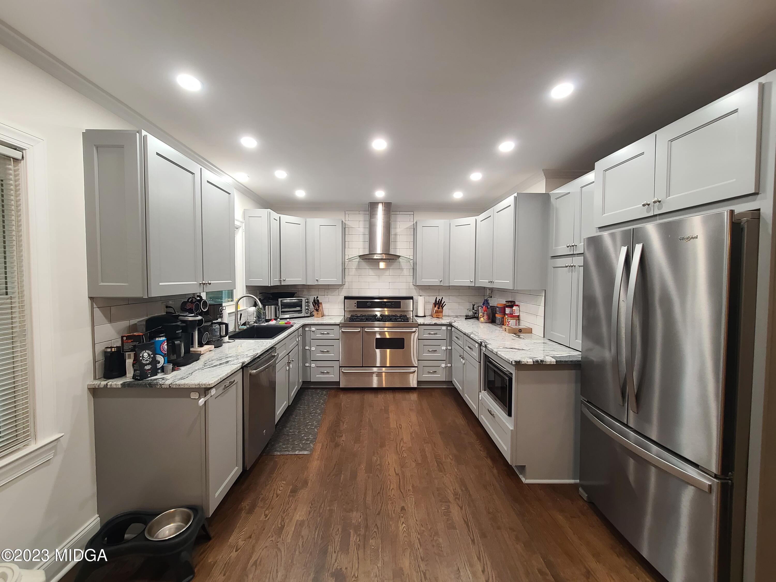 2638 Riverview Road Macon, GA 31204 - Photo 9 of 24 a large kitchen with a center island wooden floor stainless steel appliances and cabinets