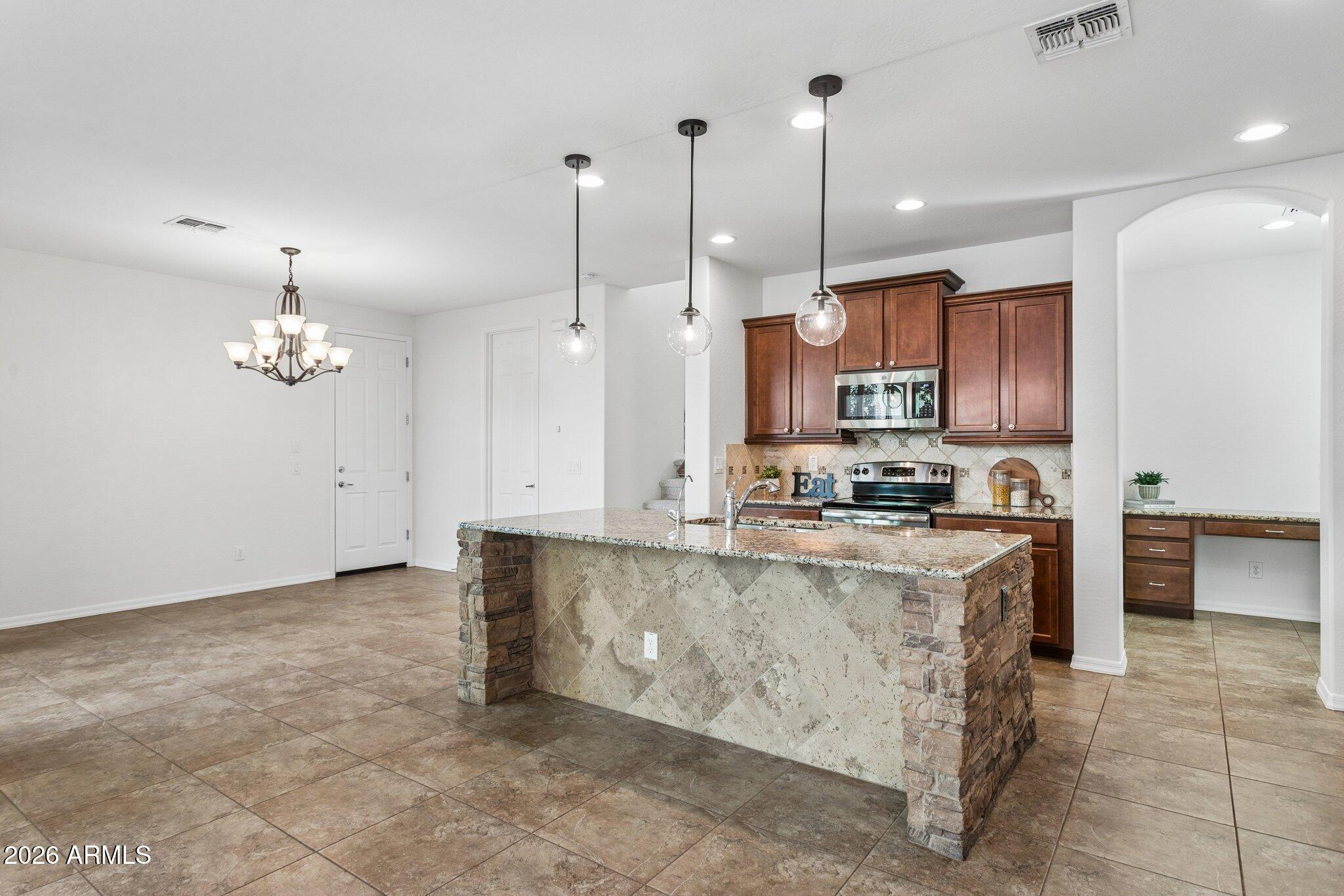 922 South Agnes Lane Gilbert, AZ 85296 - Photo 8 of 43 a large kitchen with kitchen island a sink a center island and stainless steel appliances
