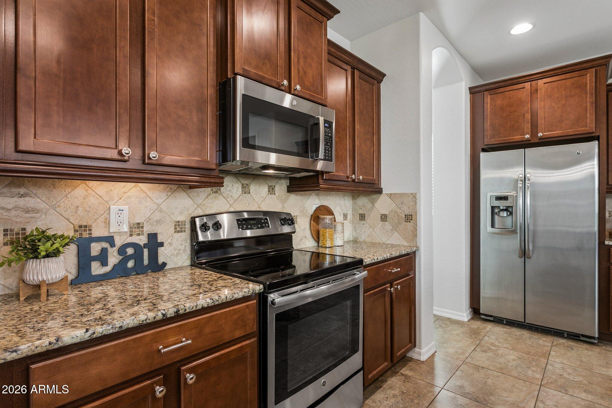 922 South Agnes Lane Gilbert, AZ 85296 - Photo 9 of 43 a kitchen with stainless steel appliances granite countertop a stove a sink and a microwave