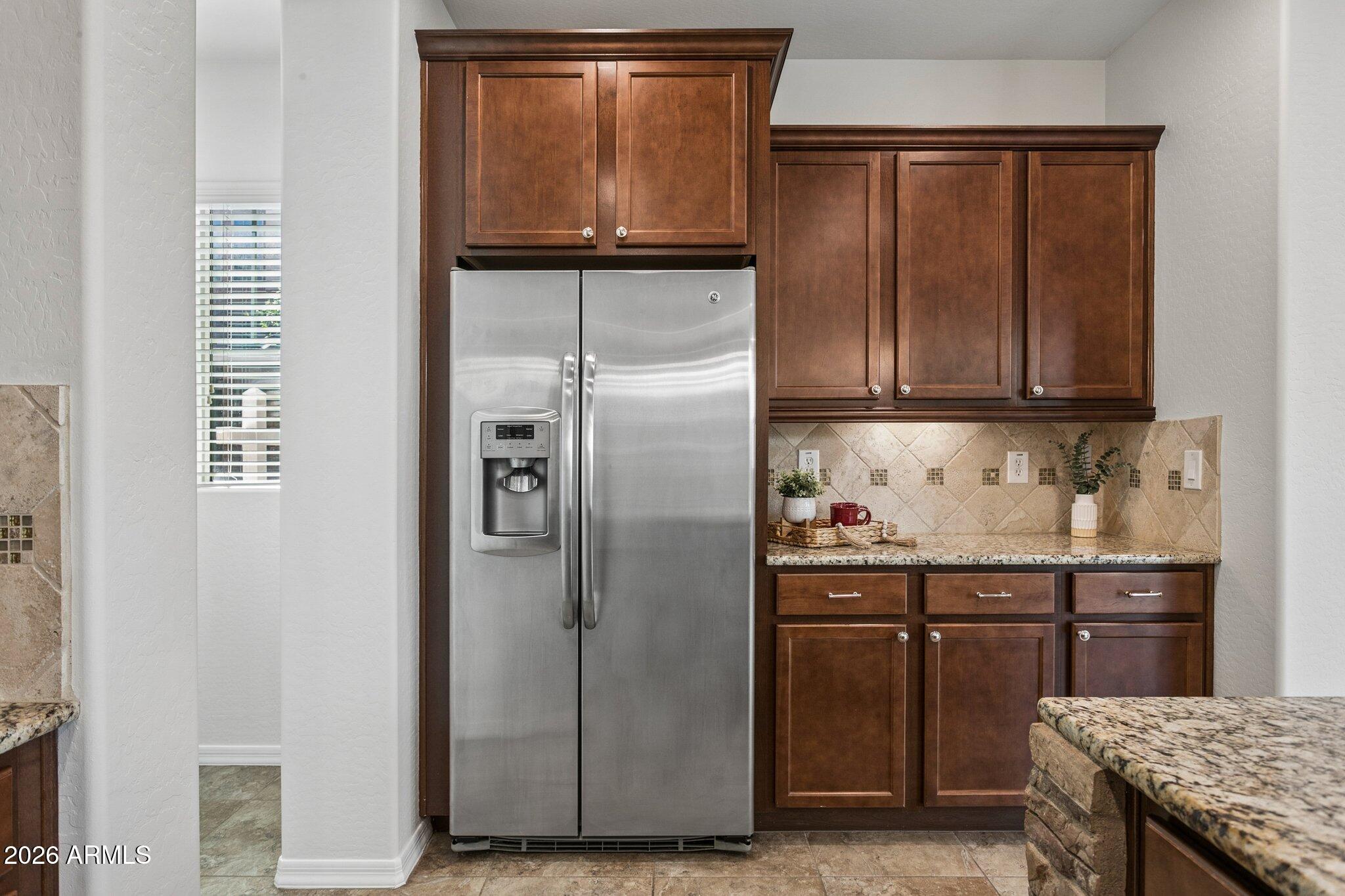922 South Agnes Lane Gilbert, AZ 85296 - Photo 10 of 43 a kitchen with granite countertop a refrigerator and cabinets