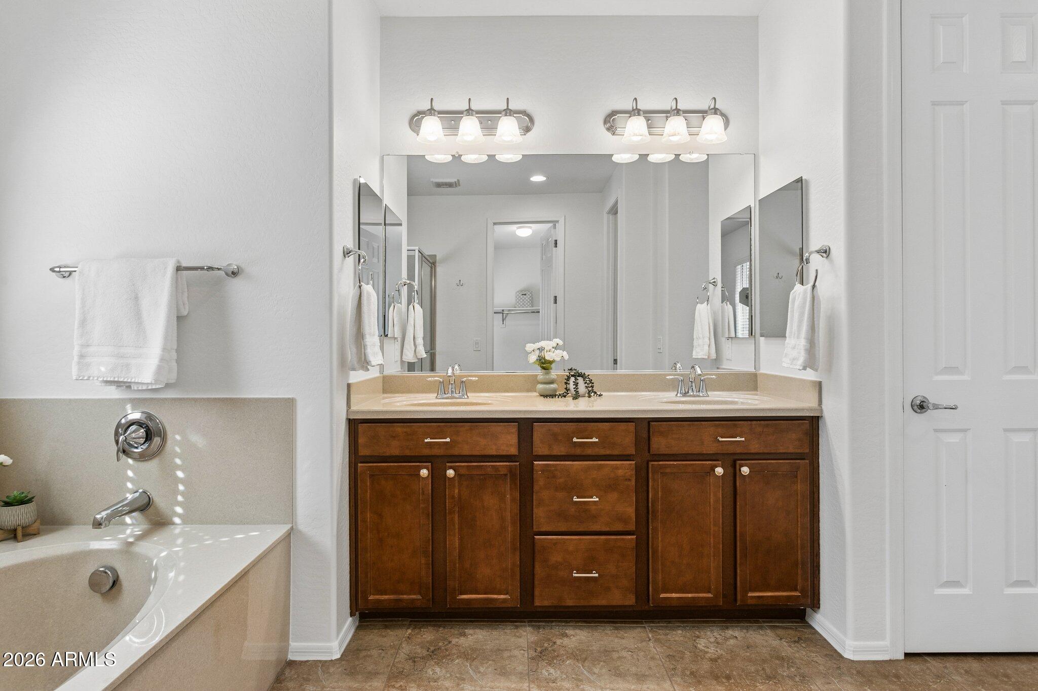 922 South Agnes Lane Gilbert, AZ 85296 - Photo 20 of 43 a spacious bathroom with a granite countertop sink a mirror and a bathtub