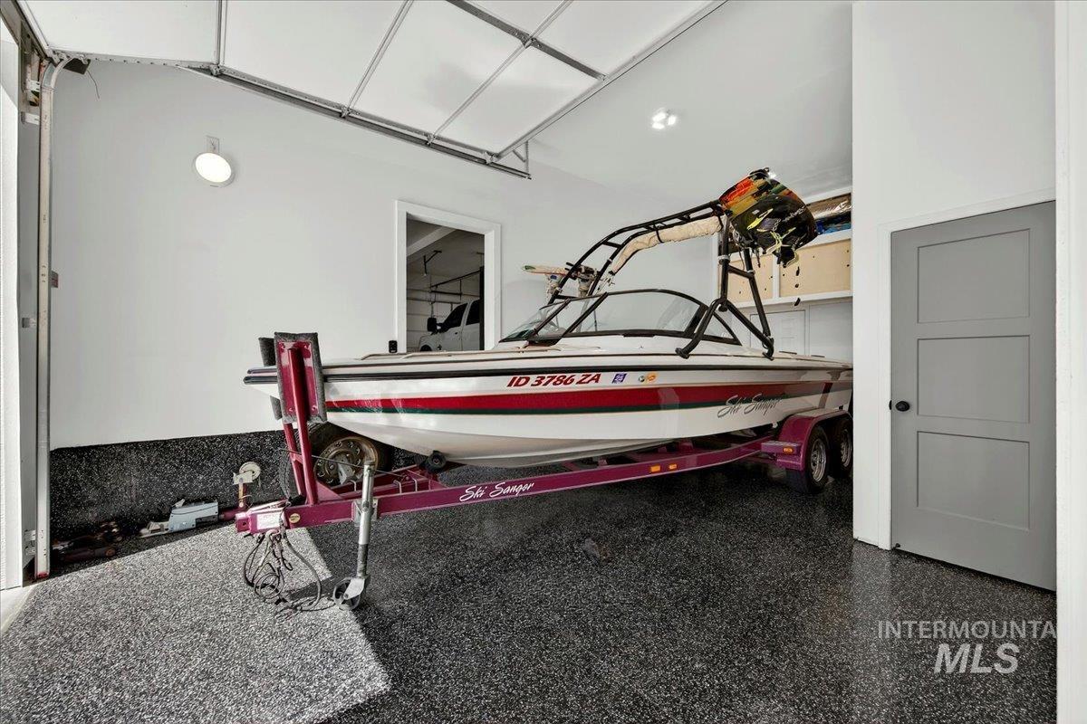414 East Shafer View Drive Meridian, ID 83642 - Photo 40 of 50 Spacious 28'deep x 11' wide boat bay garage featuring a durable epoxy floor, white painted walls, overhead lighting, and a modern paneled exterior door, upper storage cabinets & spacious under stair storage, exterior hot water hose bib, driveway 42x23!