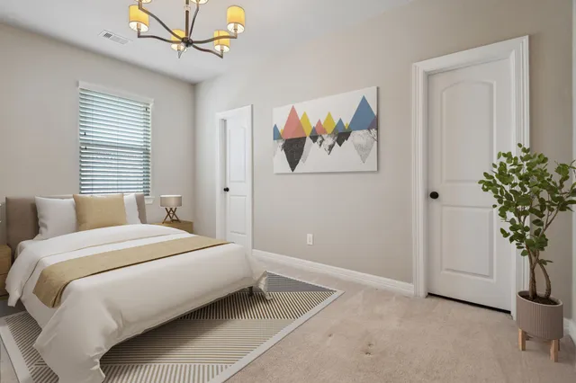 a bedroom with a large bed and a potted plant