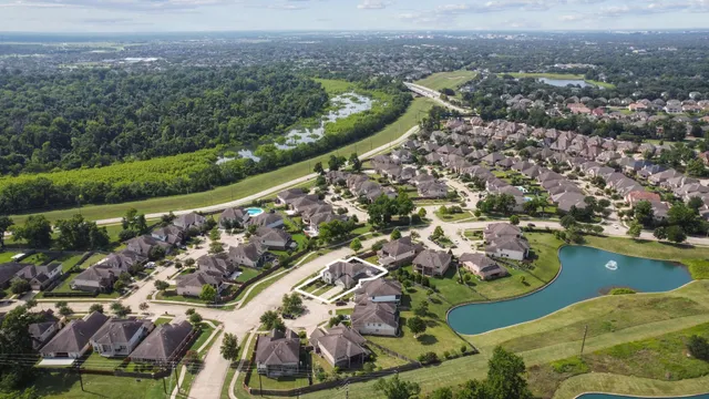an aerial view of a house with a garden and lake view