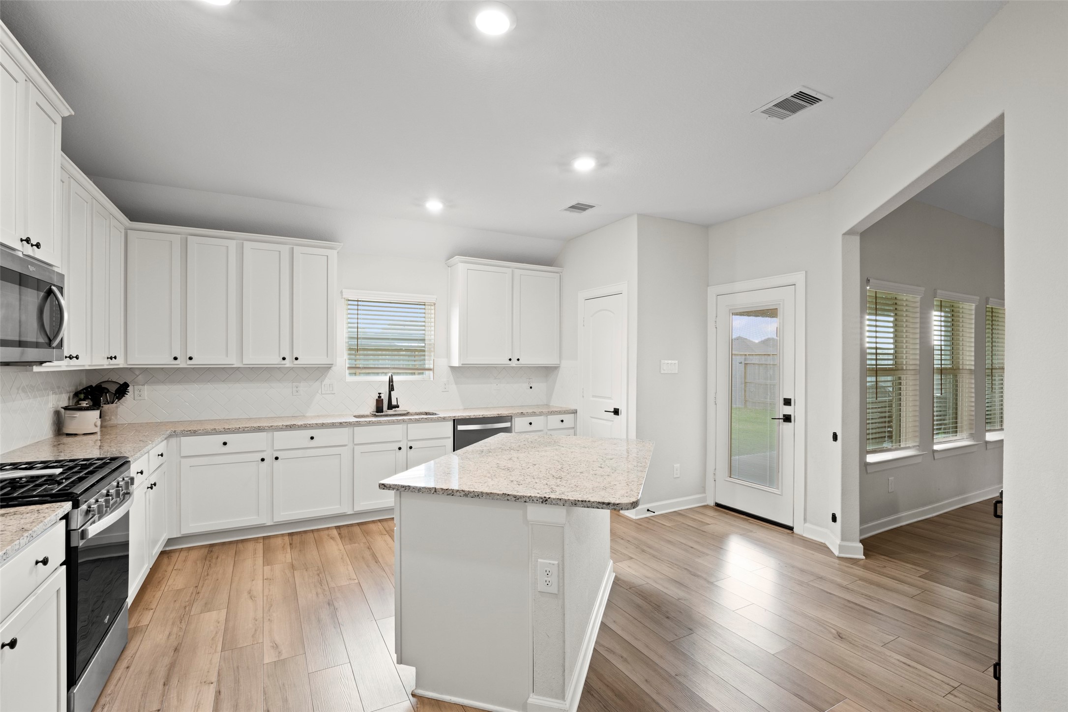 13717 Gaff Rig Drive Texas City, TX 77510 - Photo 6 of 28 a large kitchen with stainless steel appliances granite countertop a stove a sink a refrigerator and white cabinets with wooden floor
