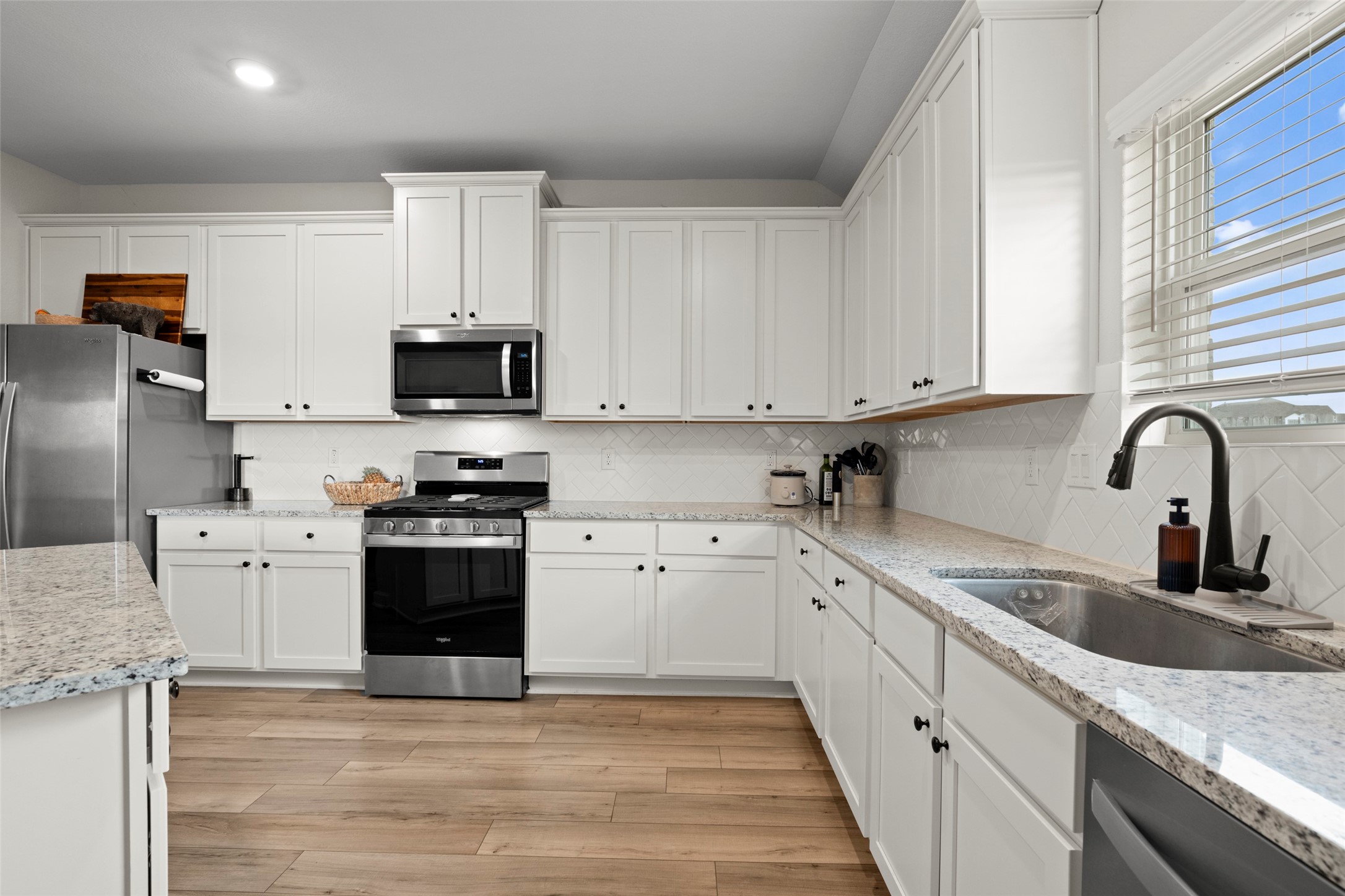 13717 Gaff Rig Drive Texas City, TX 77510 - Photo 7 of 28 a kitchen with granite countertop a sink stainless steel appliances and white cabinets