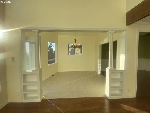 a view of a hallway with wooden floor and a living room