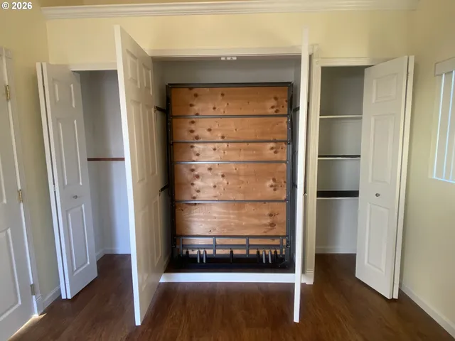 a view of walk in closet with wooden floor