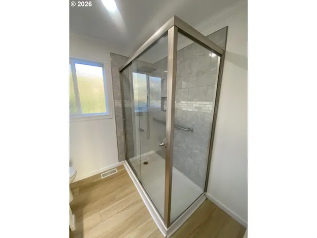 a bathroom with a glass shower door and a sink