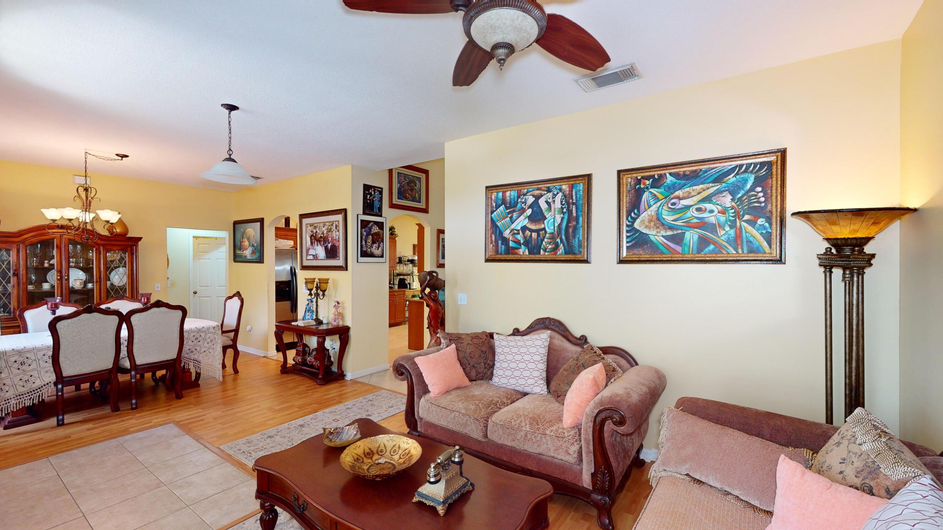 744 Southwest Monsoon Road Port St. Lucie, FL 34953 - Photo 2 of 12 a living room with furniture and a chandelier