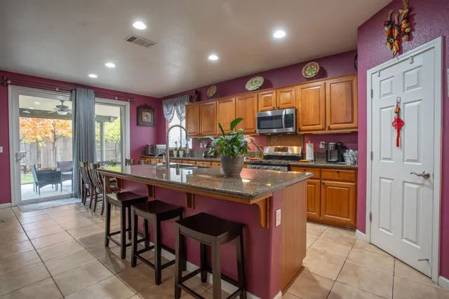 a kitchen with stainless steel appliances granite countertop a stove a sink and a refrigerator