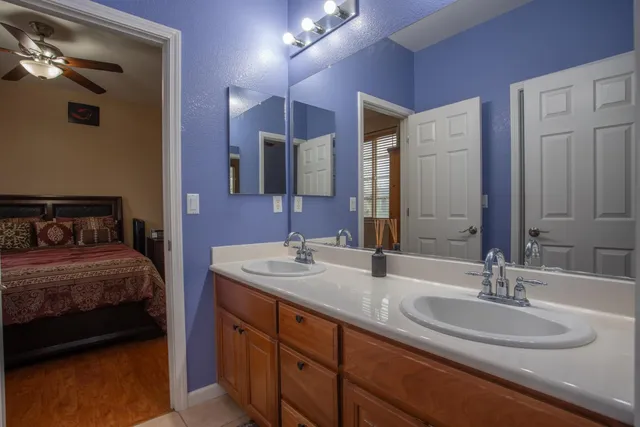 a en suite bathroom with a double vanity sink and a mirror