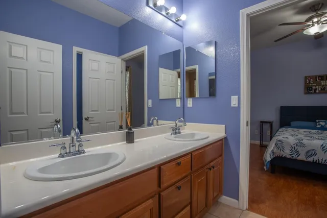 a en suite bathroom with a double vanity sink and a mirror