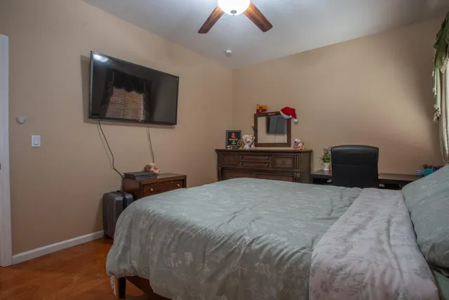 a bedroom with a bed and a lamp on dresser
