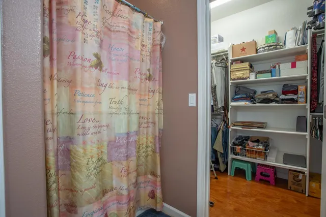 a view of walk in closet with clothes and shoes