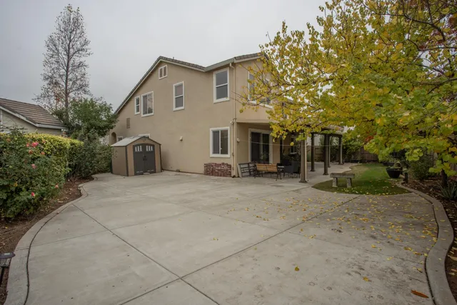 a view of a house with backyard and sitting area