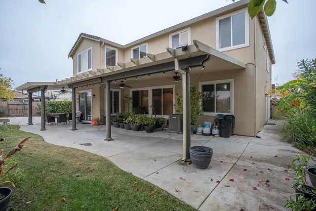 a view of a porch with couches and table and chairs under an umbrella