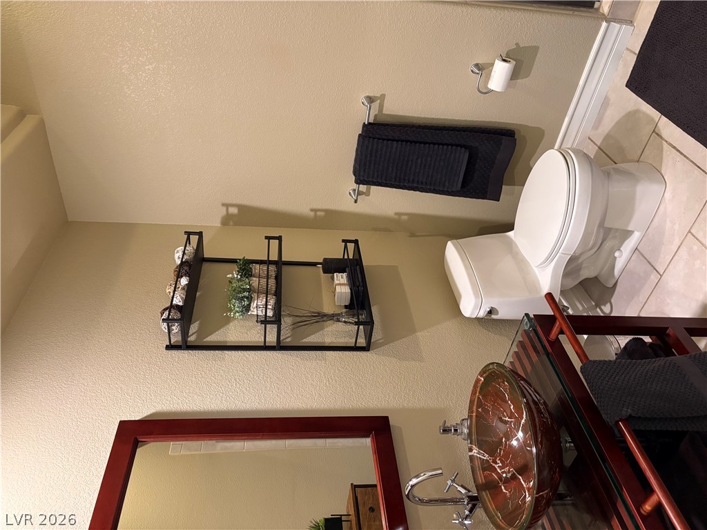 977 Rhyolite Terrace Henderson, NV 89011 - Photo 25 of 33 Tiled flooring and a modern vessel sink define this thoughtfully designed bathroom space.